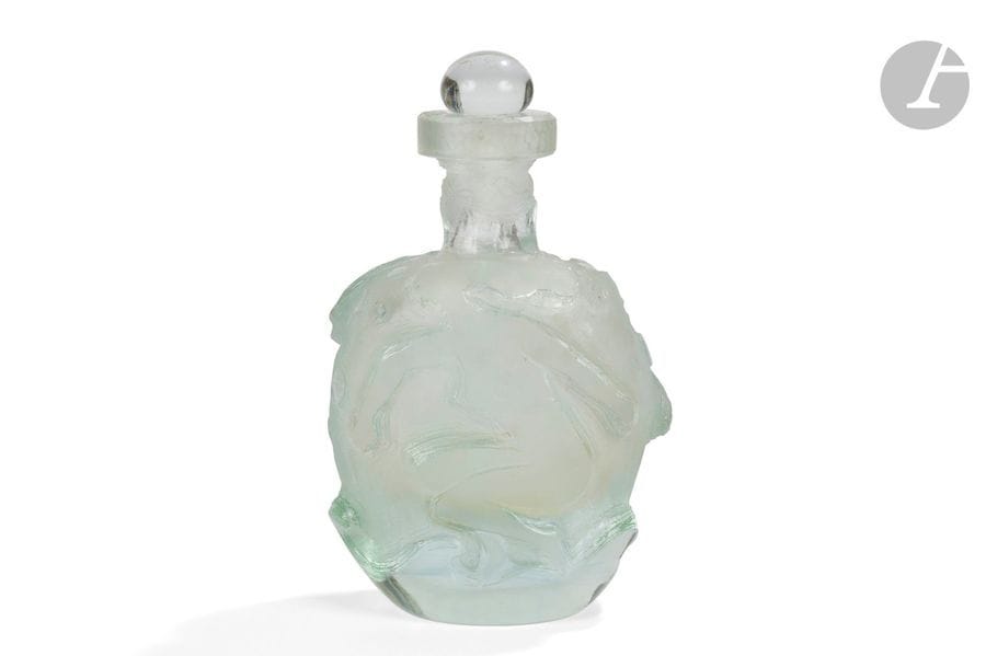 RENÉ DENIEL (NÉ EN 1947) 
Nus féminins 
Flacon ovoïde méplat à col cheminée. Épreuve en verre teinté vert d’eau, à décor anthropomorphe double face profondément travaillé l’acide et au burin. Bouchon sphérique aplati en verre incolore. Signé R. DENIEL France sous la base. H. 22,5 cm