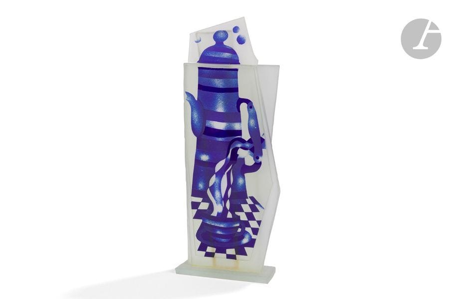 JEAN-PAUL RAYMOND (NÉ EN 1948) 
Cafetière et tasse
Sculpture-flacon. Épreuve en plaques de verre multicouche et collées, le décor dégagé à l’acide traité bleu sur fond finement granité. Signée RAYMOND à la pointe sur la tranche de la base. H. 23,5 cm 