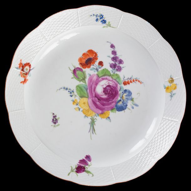 Meissen

Paire de plats ronds à bord contourné en porcelaine à motifs de vannerie en léger relief sur le bord et à décor polychrome de bouquets de fleurs et tiges fleuries.

Marqués : épées croisées et étoile en bleu, et marque d'offices en pourpre.

Fin du XVIIIe siècle (égrenures).

D : 25 cm