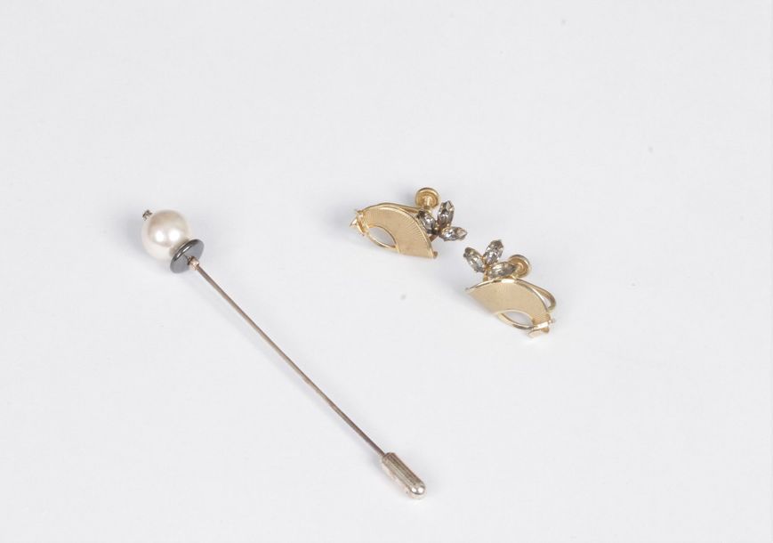 Lot de bijoux fantaisie comprenant : une paire de motifs d’oreilles dessinant des éventails, une épingle de revers sommée d’une perle imitation.