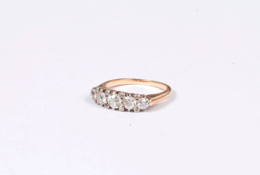 Bague en or 18K (750), ornée d’une ligne de 5 diamants ronds de poids croissant scandés de petits diamants taillés en roses. Tour de doigt : 53/54. Poids brut : 4,1 g (égrisures)