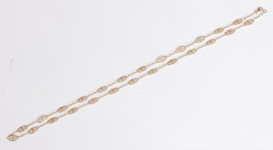 Collier en or 18K (750), articulé de maillons ovales filigranés. Poids : 9,4 g