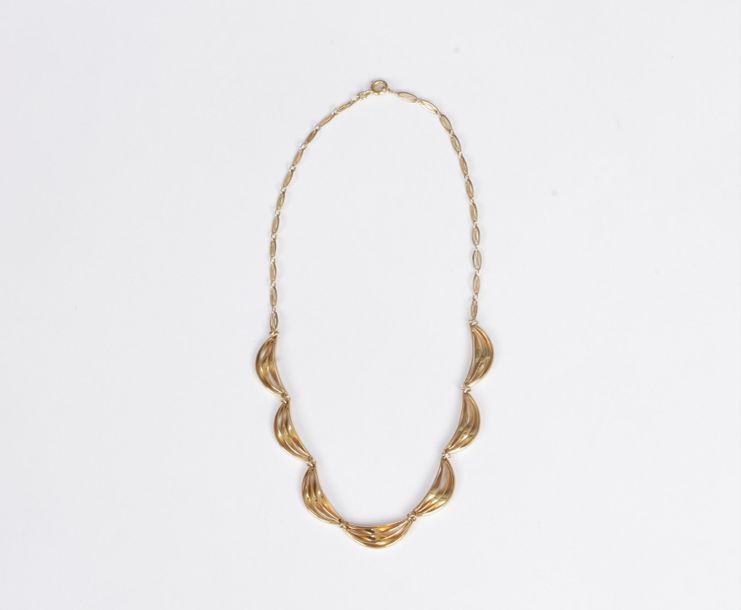 Collier en or 18K (750), orné au décolleté de motifs en demi-lunes drapées. Longueur : 35 cm environ. Poids : 13,4 g