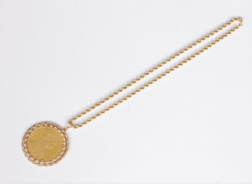 Pendentif en or 18K (750) orné d’une pièce en or à l’effigie de François Joseph Ier, coulissant sur une chaîne torsadée en or 18K. Poids : 36,6 g