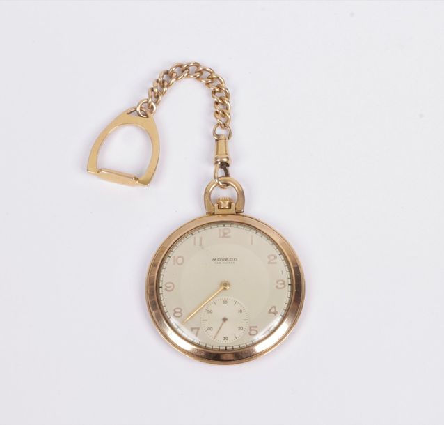 MOVADO. Vers 1930
N° 6919-540037 Montre de poche en or 18k (750), cadran peint, index chiffres arabes formant les heures, trotteuse à 6h, mouvement à remontoir signé. La montre est accompagnée d’une chaîne en or ornée d’un étrier. Cadran, boîtier et mouvement signés. Diamètre : 45 mm Poids brut : 62,6 g