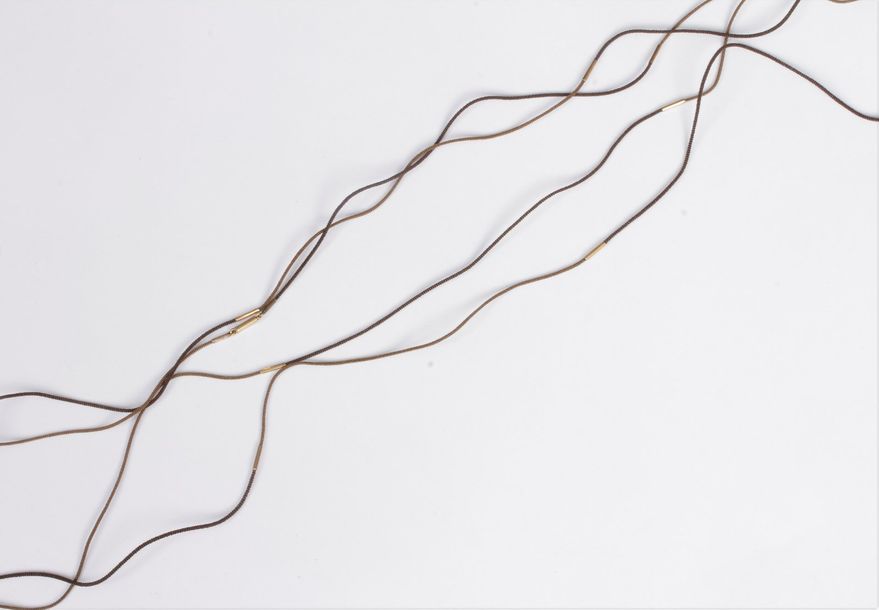 Rare chaîne en cheveux tressés de deux couleurs, monté en or 14K (585). Travail du XIXe siècle. Longueur : 200 cm environ