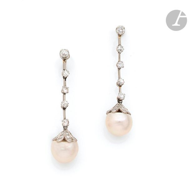 Paire de pendants d’oreilles en platine et en or gris 18K (750) composés chacun d’une ligne de diamants ronds et carrés alternés, terminés par une demi-perle de culture. Hauteur : 5,5 cm environ. Poids brut : 12,6 g