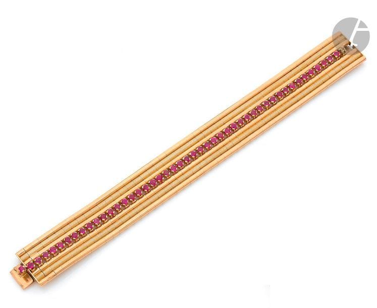 18K (750) gold ribbon bracelet, decorated with a line of natural and synthetic round rubies. Italian work of the 1950s. Dimensions: 2 x 18.7 cm approximately. Weight: 72.5 g