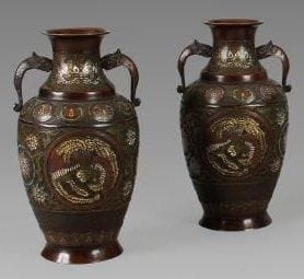 Paire de vases en bronze à patine brune et émaux cloisonnés, décor de médaillons de phénix sur un fond de lotus stylisés. Deux anses en forme de tête de qilong. Au revers de la base, la marque apocryphe de «Xuande». Japon, vers 1900. Hauteur: 36 cm.