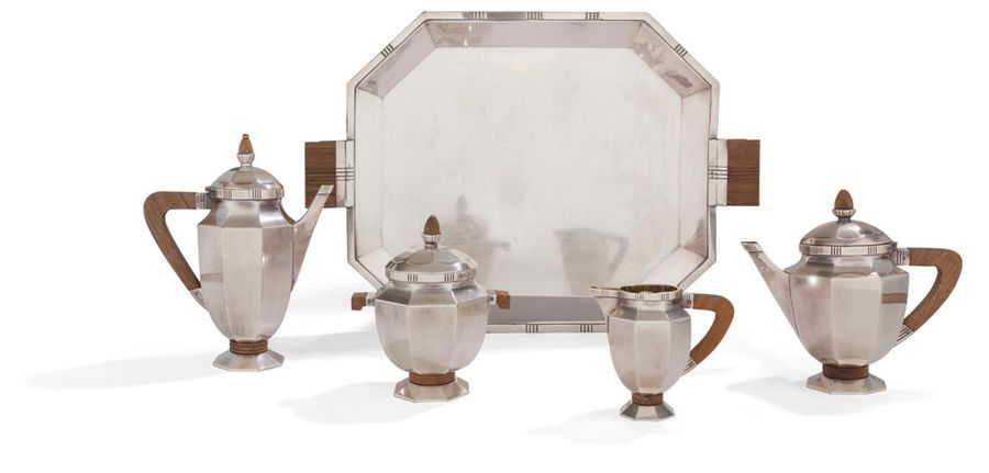 GALLIA 1931 - 1935

Gallia metal tea/coffee maker and wooden sockets, consisting of a coffee pot, a teapot, a covered sugar bowl and a milk jug with its octagonal shaped tray. The shaped pieces rest on an octagonal pedestal, reminiscent of the shape of the tray, recalling the shape of the body and the lid topped with a wooden socket.

Dimensions of the tray without the handles: length: 46.3 cm - width: 40 cm 

Height: from 25 cm to 11.3 cm

Condition: good condition of the silver