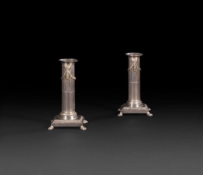 DIJON 1779 - 1780

Pair of silver toilet candlesticks. The square base rests on four claw feet, the start of the shaft is chiselled with a frieze of laurel, the fluted shaft is enhanced with knots of falling foliage drapery. Complete with bobèches, not punched but engraved with the arms of Marie Pérard, wife of Louis Janon, Parliament Counsellor, Commissioner for Requests in Dijon, as well as on the reverse of the candlesticks. They keep in the bobèches the system of pushers allowing to push back the melted wax.

Net weight: 671.60 g - height: 15 cm - dimensions of the base: 8.3 cm x 8.3 cm
Master goldsmith : Jean-Baptiste BRUNOT, received in 1773