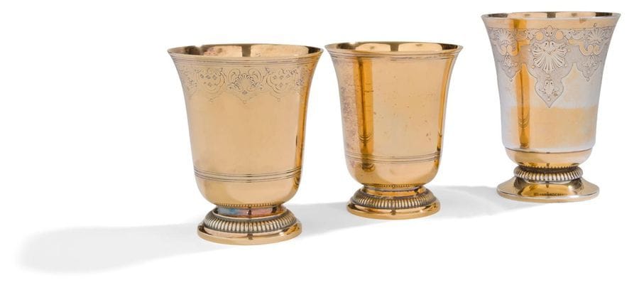 FRANCE XXe SIÈCLE

Ensemble de trois timbales tulipe en vermeil sur piédouche mouluré de godrons et gravé pour deux d'une bordure de rinceaux sur fond amati.

Poinçon minerve

Orfèvre : PUIFORCAT pour deux, le troisième non identifié.

Poids total : 565,70 g - hauteur : 12 cm et 10 cm x 2