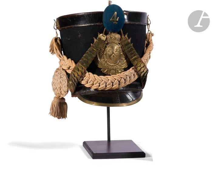 Shako d'infanterie suisse de la garde royale 1815.

Fût en cuir recouvert de drap bleu. Calotte, bourdalou et visière en cuir verni. Motifs d'attache du cordon raquette aux mufles de lion, plaque aux Grandes Armes royales, bossettes aux fleurs de lys et jugulaires à écailles doublées de cuir en laiton. Coiffe intérieure en cuir.

Pompon demi-sphérique en drap bleu au chiffre " 4 " en laiton découpé.

B.E. Époque Restauration.