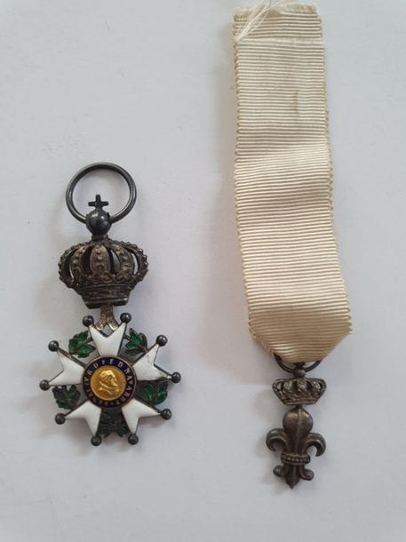 FRANCE-RESTAURATION 
ORDRE DE LA LÉGION D’HONNEUR – DÉCORATION DU LYS
Deux décorations : 
- Étoile de chevalier de la Légion d’honneur du 4e type en réduction à centres modifiés Restauration. Argent, or et émail (éclats). Poinçon au faisceau de licteur (1809-1819). 
49 x 26 mm - Poids brut : 8 g 
- Lys sous couronne. En argent. Anneau guilloché. Fin ruban.
25 x 10 mm - Poids brut : 2,8 g
T.B. à T.T.B. 