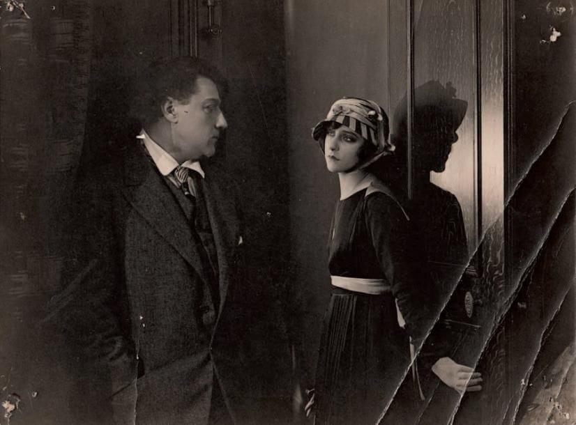 [Sacha GUITRY et Yvonne PRINTEMPS]
Photographie du film Un roman d'amour et d'aventure, [fin 1917]. Tirage argentique d'époque, 16,5 x 22,5 cm (plis, trous de punaises aux coins); cachet encre G. Troussier au dos. Très rare photographie du premier film joué par Sacha Guitry, Un roman d'amour et d'aventure, réalisé par René Hervil et Louis Mercanton fin 1917 sur un scénario de Sacha Guitry, qui y joue un double rôle de jumeaux qui annonce La Vie d'un honnête homme. Ce sera le seul film muet de Guitry, qui est ici face à Yvonne Printemps. On joint 4 tirages modernes d'images du film. ABO p. 76-77.