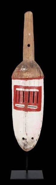 Masque «Wan Zega» MOSSI (Burkina Faso) Face blanche aux yeux en multi fentes entourés de rouge, surmontée d'une hampe ayant perdu sa touffe de fibres rouges. Bois, agrafes et clous. H: 87 cm