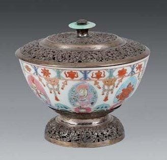 Extrême-Orient
CHINE Bol circulaire, en porcelaine décorée en émaux de la famille rose, de personnages dans des réserves Couvercle et base ajourés à rinceaux feuillagés, en argent. XIXe siècle, pièce fabriquée pour le marché tibétain (ancienne réparation). D: 12,5 cm