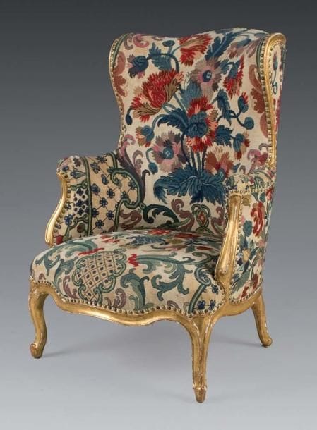 Très rare bergère à oreilles, en bois sculpté et doré. Les supports d'accotoir en léger retrait. Ceinture chantournée. Pieds cambrés nervurés. Estampille de CARPENTIER Époque Louis XV Garniture en tapisserie au point, à décor de fleurs et feuillages. H: 102 - L: 67 - P: 64 Louis Charles CARPENTIER reçu Maître le 26 Juillet 1752. La bergère à oreilles est une version du fauteuil en confessionnal, apparût sous Louis XIV.
