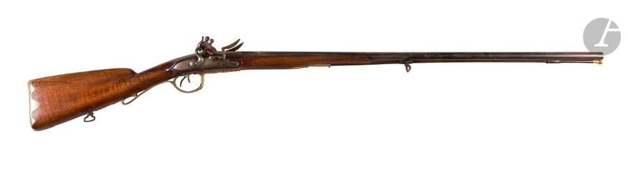 Fusil de chasse à silex, deux coups par Coulaux à Huningue. 
Canons ronds bleuis, à point de mire en argent, richement décoré à l’or et gravés de trophées de musique au tonnerre. Platines signées « Coulaux à Huninque » et chiens à corps ronds. Garnitures en laiton découpé et uni. Crosse en noyer à joue. Baguette en fanon à embout en corne. 
A.B.E. (Oxydation des canons). Vers 1750 / 1760. 

 Julien I Coulaux, arquebusier du Roi à Huningue. Son fils homonyme dirigera la Manufacture de Klingenthal.