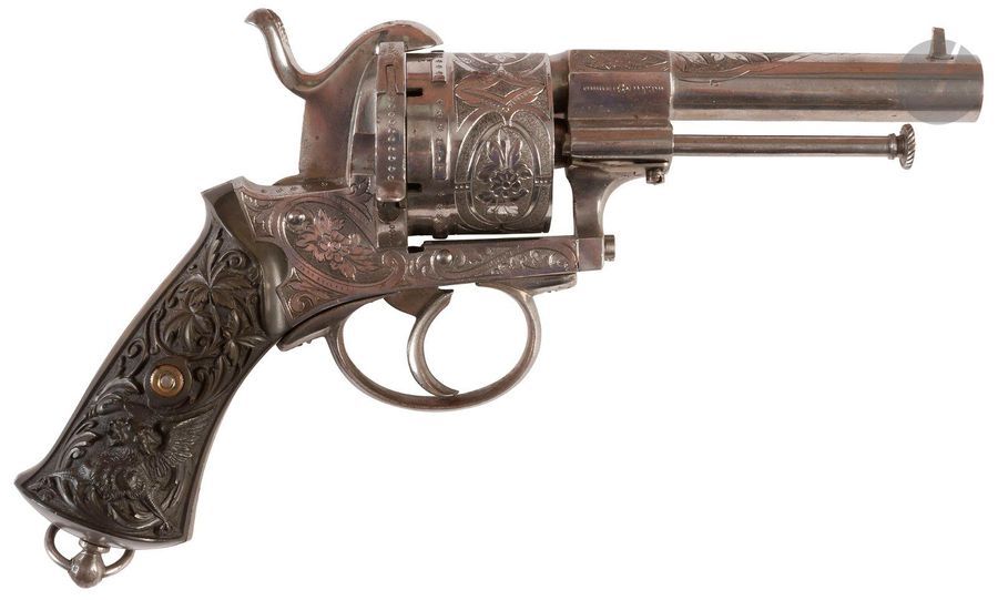Revolver à broche, six coups, calibre 12 mm 
Canon rond, à pans au tonnerre, barillet et carcasse ciselé de rinceaux feuillagés et fleurs. 
Plaquettes de crosse en fort relief à décor de feuillages et griffons. 
B.E. Vers 1870. 