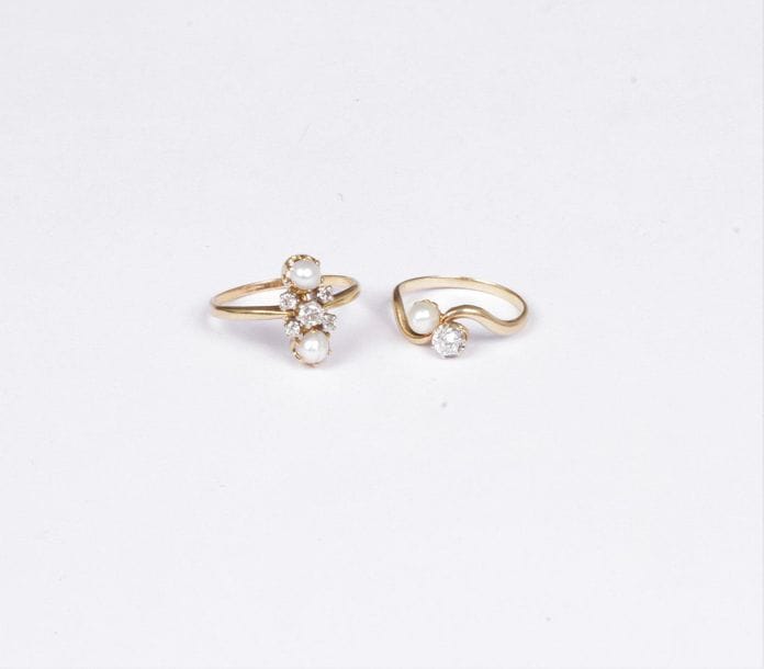 Lot de deux bagues en or jaune 18K (750), l’une croisée sertie d’un diamant rond de taille ancienne et d’une perle ; l’autre ornée de 5 diamants de taille ancienne entre deux perles boutons. Poids brut : 5,1 g
