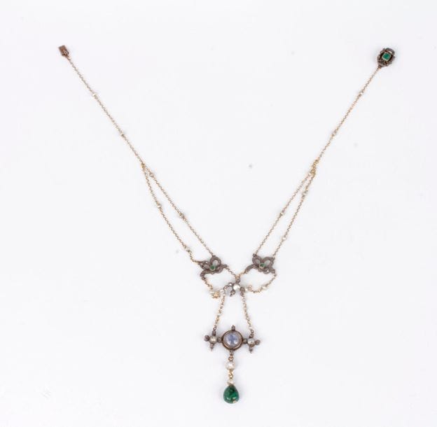 Necklace in silver and 18K (750) gold, decorated with knotted motifs set with rose-cut diamonds, pearls, holding an emerald drop in pendants, the clasp adorned with an emerald. French work from the end of the 19th century. Gross weight: 14.8 g (accident, scratches)