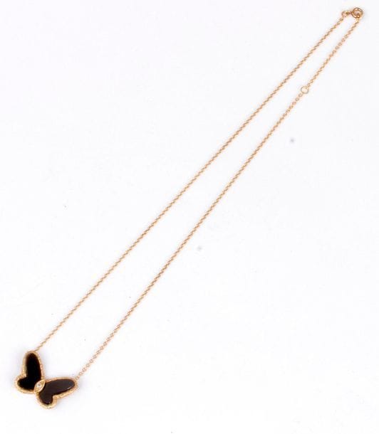 Collier en or 18K (750), orné d’un papillon, les ailes en onyx, le corps souligné d’un diamant rond. Poids brut : 6,7 g