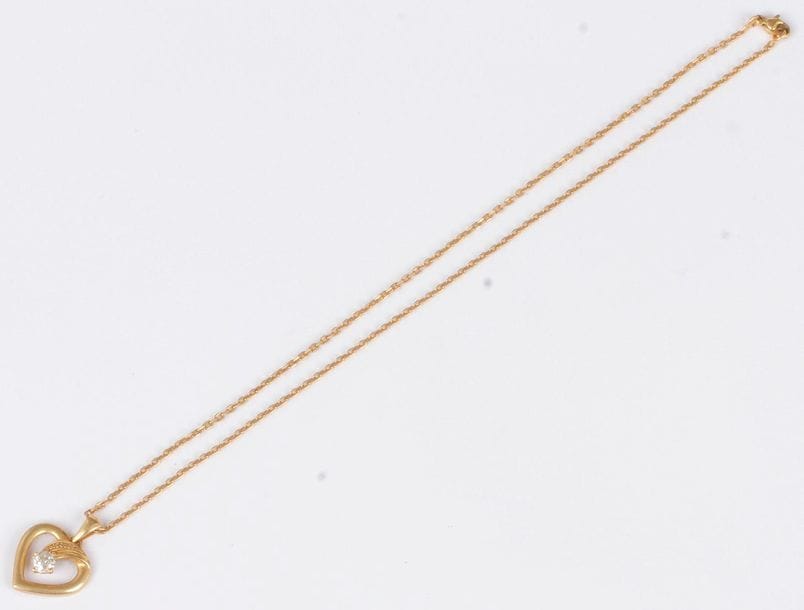 Pendentif en or 18K (750) en forme de cœur, serti d’un diamant de taille ancienne, coulissant sur une chaîne en or 18K. Poids brut : 6,3 g