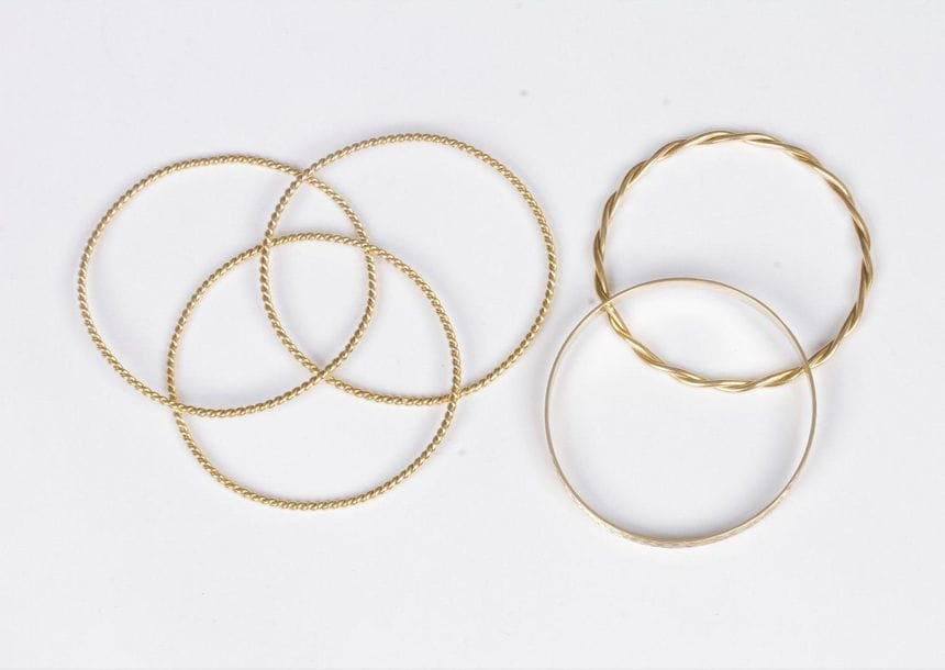 Suite de 3 bracelets, l’un en or 14K (585) ruban guilloché, les 2 autres torsadés en or 18K (750). Poids : 68,3 g