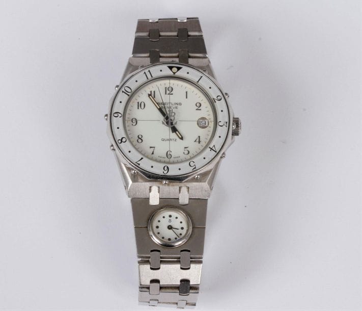 BREITLING
Montre bracelet d’homme en acier. Cadran beige, index chiffres romains. Mouvement à quartz (pile non vérifiée). Boucle déployante.