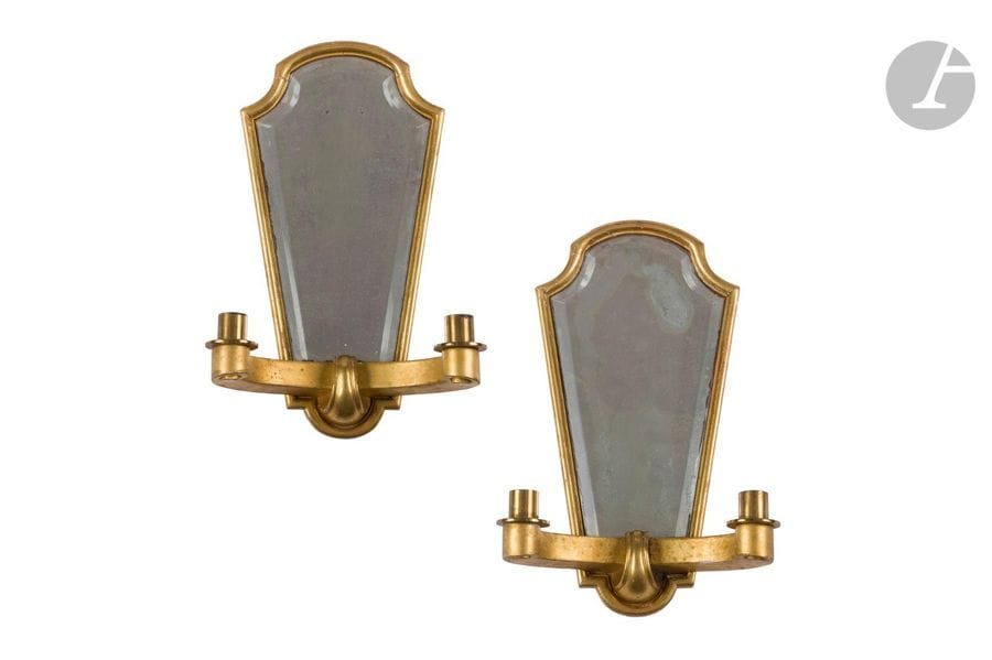 TRAVAIL DES ANNÉES 1940/50
Paire d’appliques en bois doré à deux bras de lumière chacune. Les platine à fond de miroir biseauté, les bras terminés en enroulements. Petits sauts épars de dorure, à réélectrifier, les tains des miroirs altérés. H. 37 cm