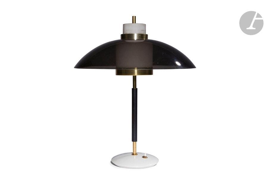 TRAVAIL ITALIEN DES ANNÉES 1960 DANS LE GOÛT DE STILNOVO
Lampe de bureau ou de salon. Le fût en métal laqué noir et laiton sommé d’un cylindre en verre dépoli et d’un abat-jour en plexiglas fumé. Base circulaire en marbre recevant l’interrupteur d’origine. H. 54 cm