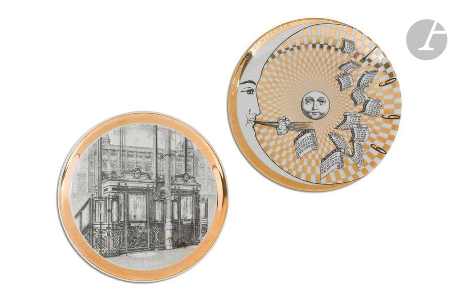 PIERO FORNASETTI (1913-1988) 
Gli asensori & 32e Platto calendario, n° 144/750
Deux assiettes. Épreuves en porcelaine ; les décors émaillés et à l’or. Chacune vendue avec son coffret d’origine d’une création de l’artiste. La première marquée au revers Da Rin C. Milano – « Gli asensori » Platto creato da Fornasetti – Ascensore del grande magazzino « La Rinascente » a Milano, P.za Duomo. Installato nell’anno 1917, l’autre marquée, également au revers, 32° Platto calendario – Creato da Fornasetti Milano Made in Italy – N° 144/750. D. 24,5 cm 