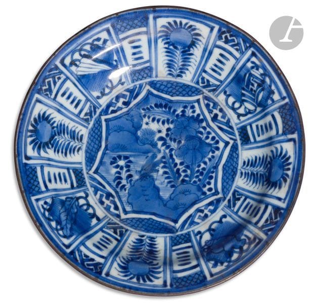 JAPAN - 17th
centuryPorcelain
plate
called "kraak", enamelled in blue underglaze with central decoration in a medallion forming a lotus flower, a cricket placed on a flowered rock, flowered panels and Buddhist symbols in reserve. The border is circled with metal. Swastika in blue underglaze on the
back.
 
Diam. 21 cm

