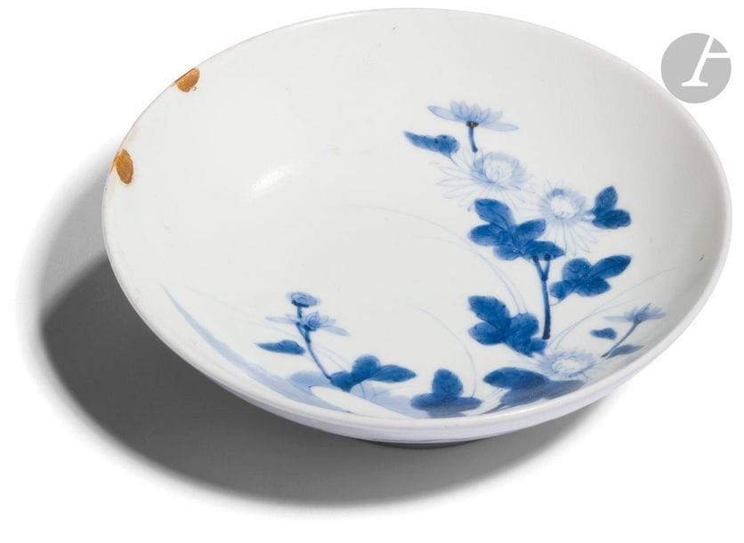 JAPAN - Beginning of the 20th centuryRound bowl
on a blue enamelled porcelain stand in the Nabeshima style with a decoration of flowering branches of chrysanthemums, two chips on the edge restored with gold lacquer called "kintsugi
".
 
Diam. 15.5 cm

