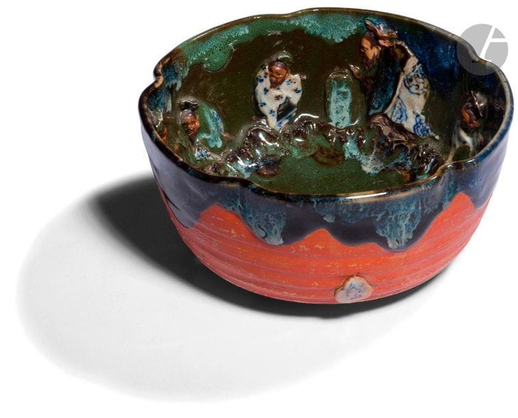 JAPON - Début XXe siècle
Bol en porcelaine à décor émaillé de coulures vertes, bleues et brunes à décor en relief en réserve de lettrés. (Petits éclats au chapeau). H. 9 cm ; diam. 18,5 cm
On joint un netsuke en porcelaine émaillée sur le biscuit en forme de singe debout. H. 8,6 cm