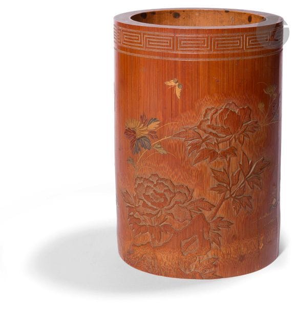 JAPON - Époque MEIJI (1868 - 1912)
Pot à pinceaux en bambou à décor sculpté en léger relief partiellement laqué or, rouge et argent, de papillons en vol parmi les fleurs. Signature (Craquelure).
H. 16,5 cm ; diam. 11,5 cm