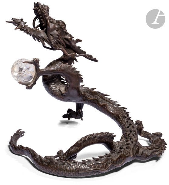 JAPAN - MEIJI period (1868 - 1912
)Dragon with three bronze claws with brown patina holding in its left paw the sacred rock crystal pearl. H. 23,1 cm
