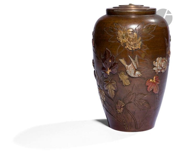 JAPON - Époque MEIJI (1868 - 1912)
Vase en bronze à décor en relief en laiton doré et shibuichi de branches de chrysanthèmes, oiseaux perchés et en vol. 
H. 24,5 cm ; monté en lampe.