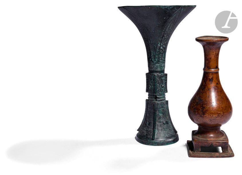 CHINE
Deux vases en bronze, l’un gu à patine verte de style archaïque, l’un à patine marron sur socle carré de forme bouteille. 
H. de 21,3 à 27,1 cm