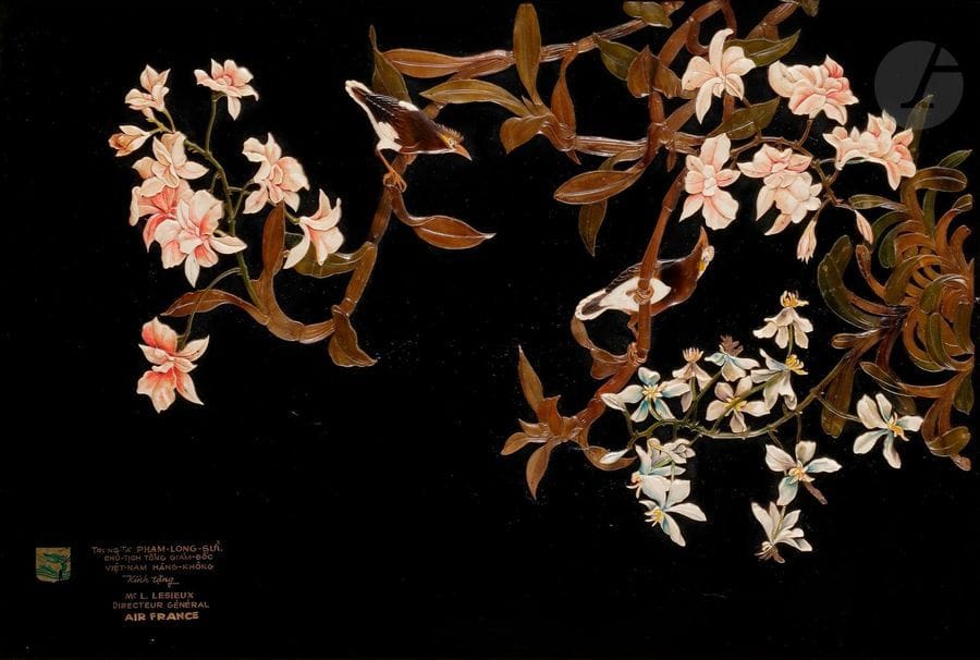 VIETNAM - XXe siècle
Nguyen Than Ley (1919 - 2003)
Panneau en laque noire à décor incrusté d’imitation d’agate et serpentine, d’ivoire teinté d’oiseaux perchés dans des branches fleuries. 
Dédicace à M. Lesieux, directeur général Air France en bas à gauche. 
Signé en bas à gauche. (Manques d’incrustations).
40 x 60 cm ; encadré.