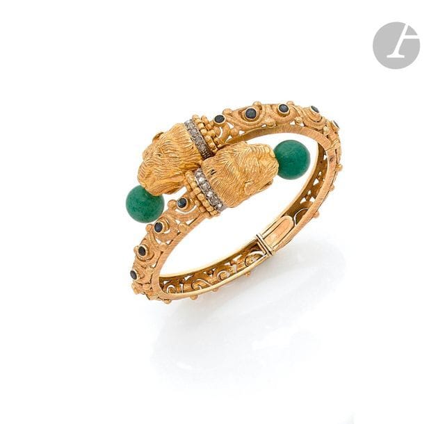 ZOLOTAS
Bracelet ouvrant en or 18K (750), ajouré, les extrémités sculptées en têtes de lionnes, les gueules ouvertes sur une bille de quartz aventuriné, les colliers sertis de diamants taillés en roses, agrémenté de saphirs ronds. Poinçon de maître. Travail grec des années 1970.
Longueur : 16 cm environ.
Poids brut : 64,3 g