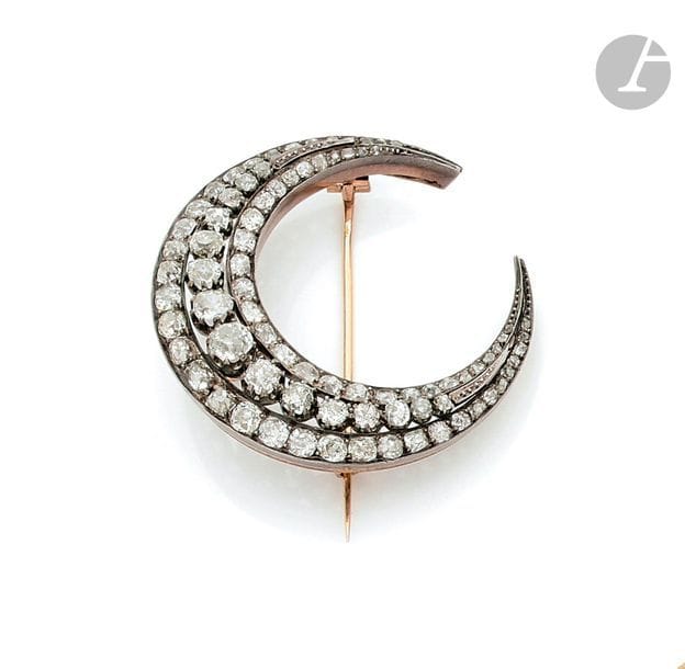 Broche croissant de lune en or 18K (750), entièrement sertie de diamants de taille ancienne sur argent. Travail français du dernier quart du XIXe siècle.
Diamètre : 5 cm environ.
Poids brut : 18,5 g (chocs)