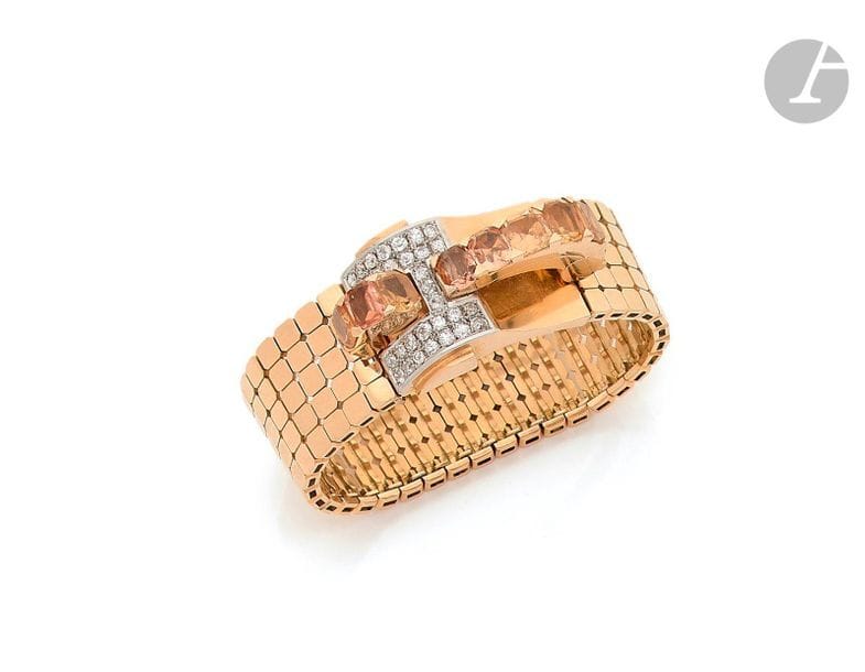 Bracelet ruban souple en or 18K (750), les maillons en petits carrés juxtaposés, le fermoir formant un pont serti d’une ligne de citrines de forme coussin, pavé de diamants ronds de taille ancienne. Travail des années 1940.
Dimensions : 17 x 2 cm environ.
Poids brut : 79,1 g (égrisures)