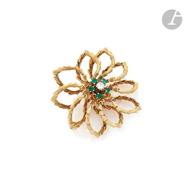 Broche rosace en or 18K (750) guilloché, piquée d’émeraudes, ornée d’un diamant rond de taille brillant. Travail des années 1960.
Hauteur : 5 cm environ.
Poids brut : 21 g