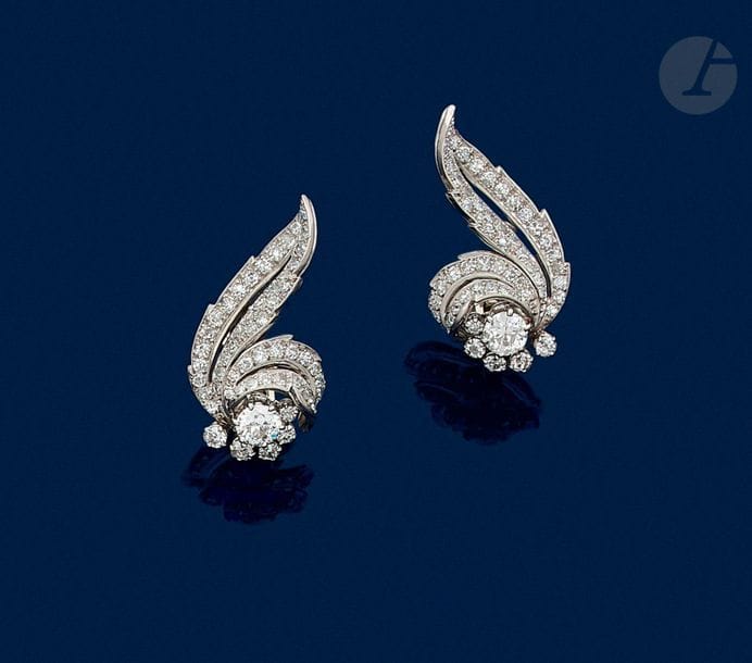 Paire de motifs d’oreilles en platine et en or gris 18K (750) formant des feuilles stylisées serties de diamants de taille ancienne dont un plus important. Travail français des années 1950.
Hauteur : 3,5 cm environ.
Poids brut : 17 g (système permettant de les porter aussi en clips de revers)