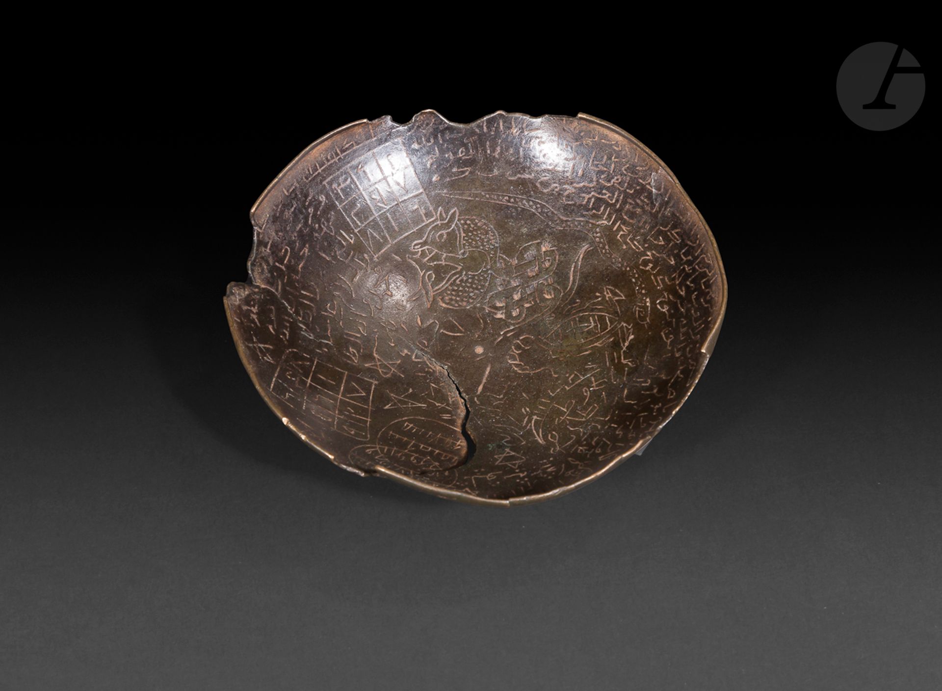 Paire de petites coupes magiques en alliage cuivreux, Proche-Orient, probablement XIIIe siècle
La première à patine foncée, gravée de lignes d’inscriptions, de carrés magiques, d’étoiles à 5 branches, et d’autres symboles apotropaïques dont un scorpion et deux dragons aux corps entrelacés en nœud sans fin. La seconde gravé d‘un décor rayonnant intégrant des médaillons et des inscriptions variées dont des mots en arabe.
Diamètre : 11 et 13,5 cm 
Fêlures.

Two small magic bowls, Near East, probably 13th century