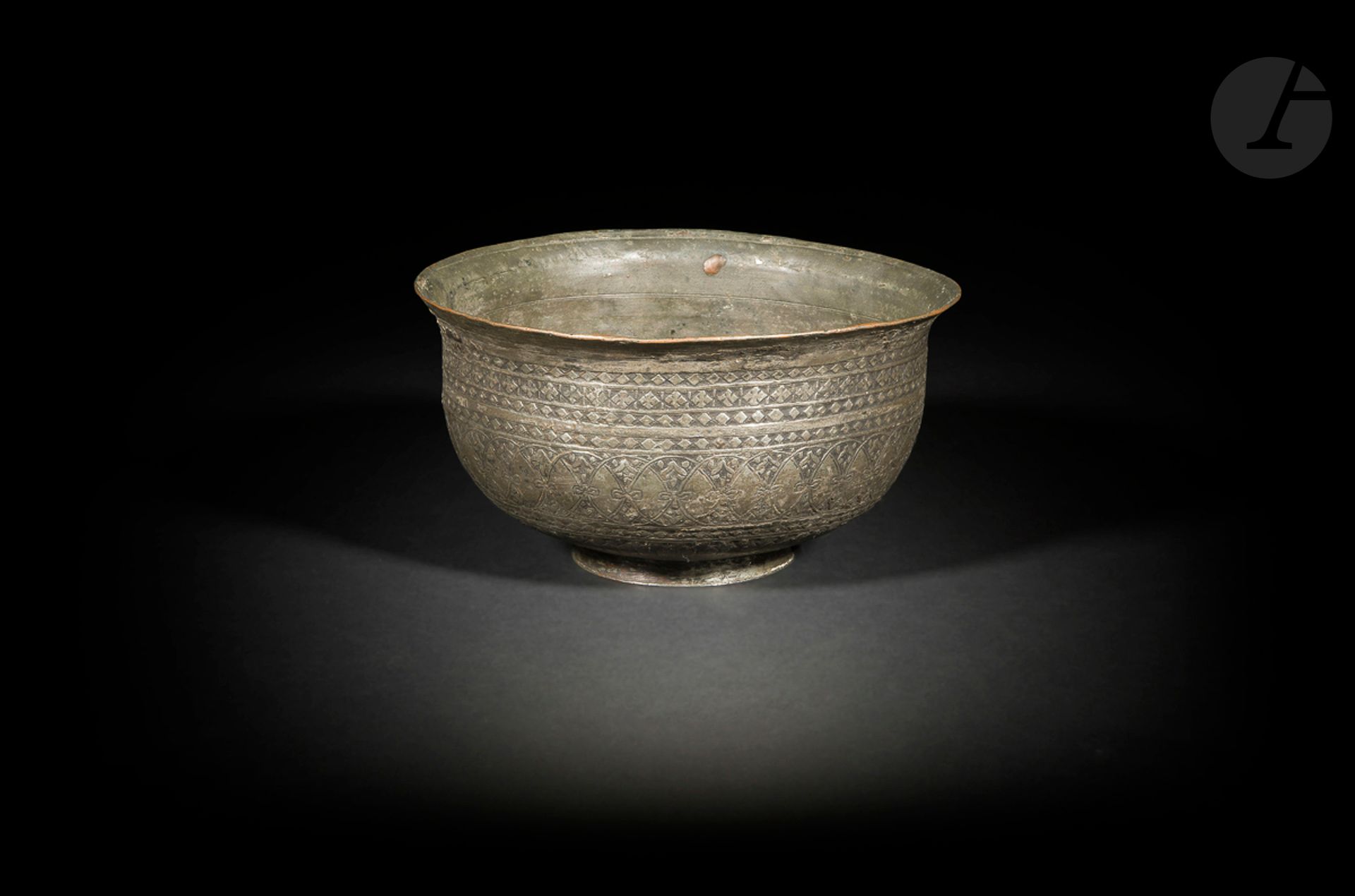 Coupe en cuivre étamé, Iran, XIXe siècle, et grand bassin en laiton, Égypte ou Syrie, probablement XIXe siècle
- Coupe à panse hémisphérique sur piédouche, à décor ciselé de registres de cercles entrelacés et de motifs losangés au col. Gravée à la base «Heydar », probablement le nom du fabricant. Hauteur : 10,9 cm ; diamètre : 20 cm ; petites fentes ; - Bassin à panse tronconique en laiton, à décor ciselé de médaillons calligraphiés en thuluth intercalés de médaillons d’entrelacs de palmettes bifides. Hauteur : 24 cm ; diamètre : 29 cm ; petits enfoncements.
 
A tinned copper bowl, Iran, 19th century and a large brass basin, Egypt or Syria, 19th century