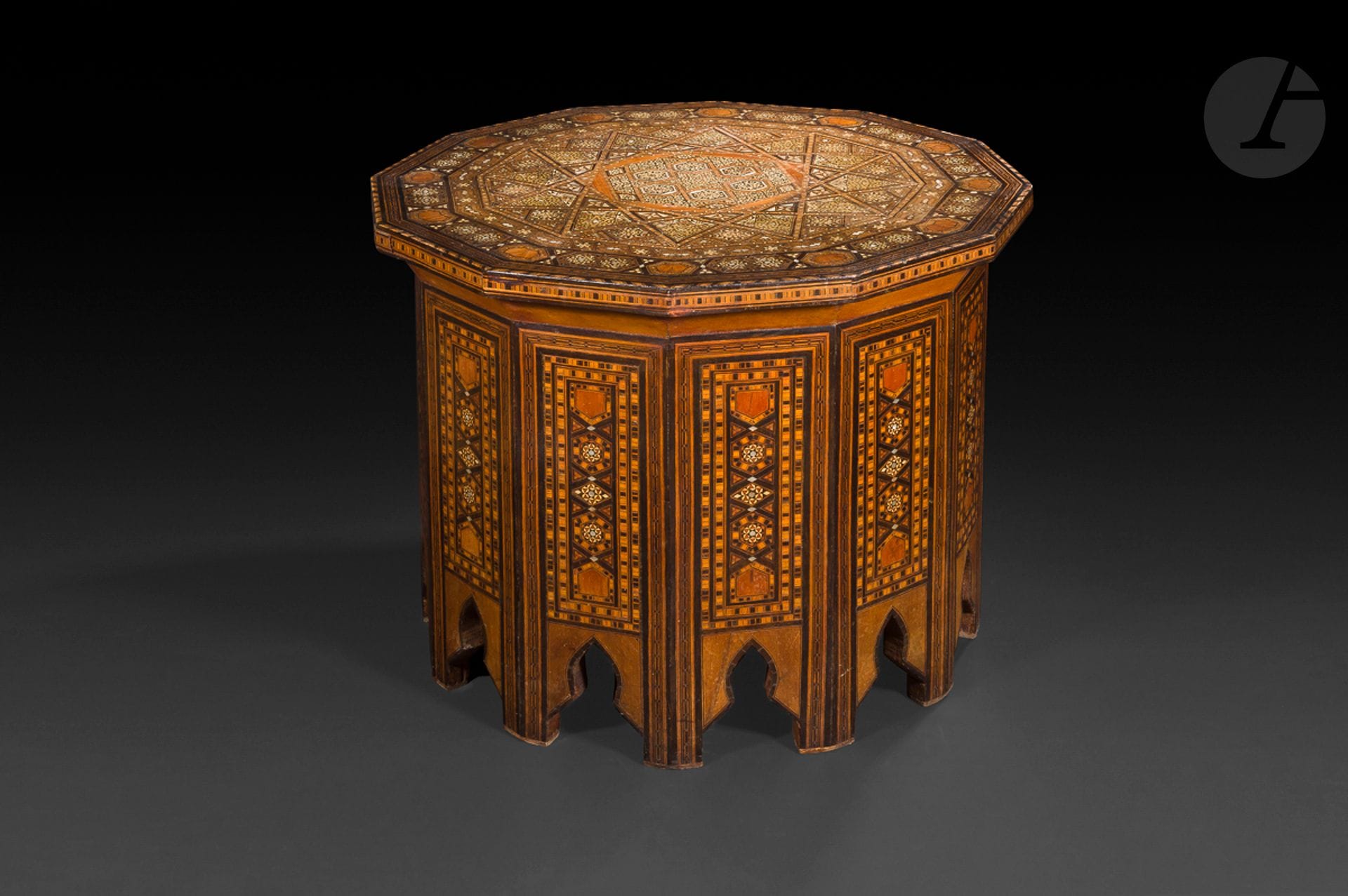 Guéridon en bois à décor marqueté, Syrie, fin XIXe - début XXe siècle
Large plateau dodécagonal reposant sur une base à pans coupés, chacun découpé en forme de niche au pied. Fin décor marqueté de bois d’essences variées, d’os et de nacre en modules géométriques dessinant une grosse rosace étoilée au centre du plateau.
Hauteur : 45 cm ; diamètre : 59,5 cm

An inlaid wooden pedestal table, Syria, late 19th – early 20th century