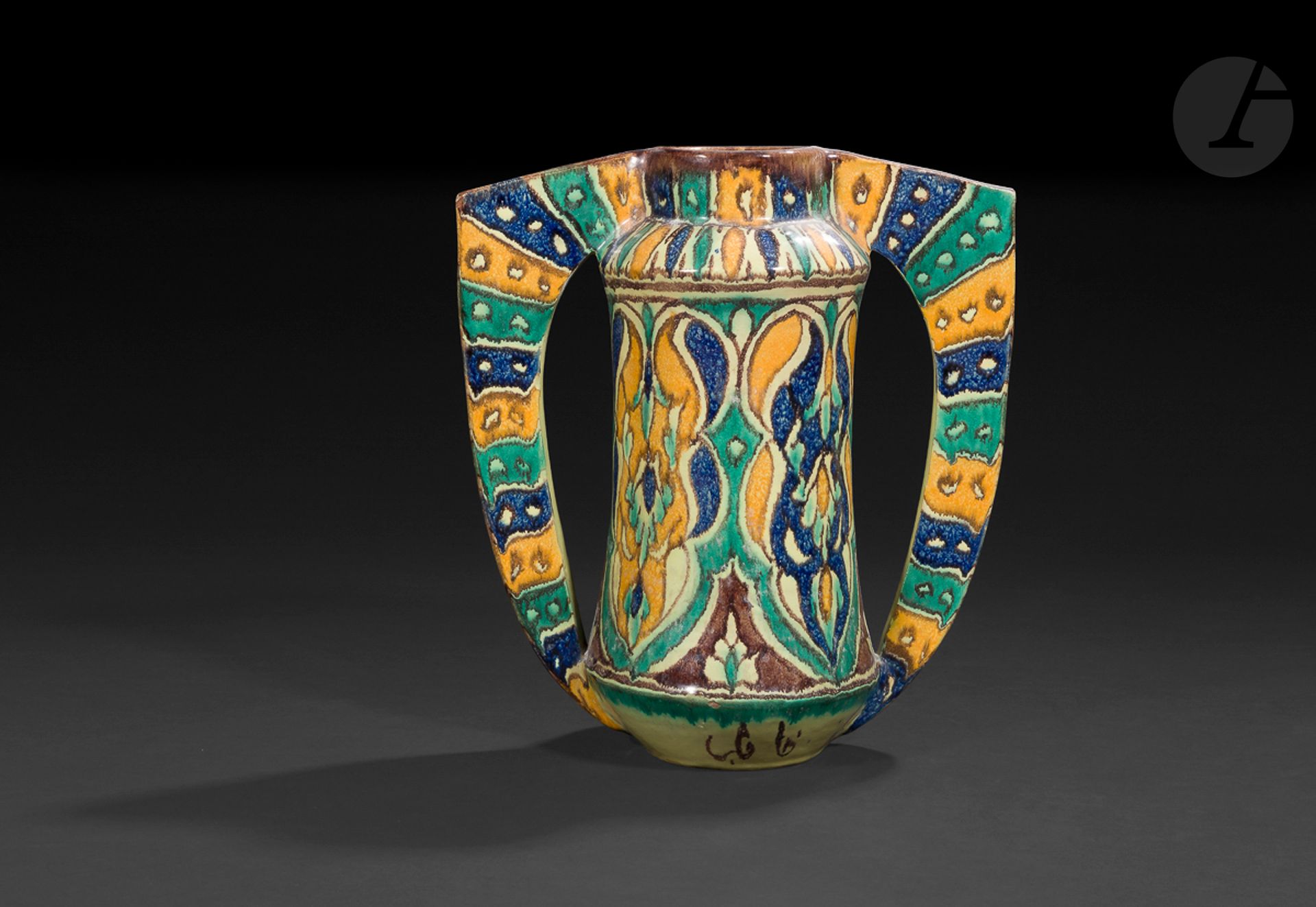 AL-MAJDOUB (1907-92), Vase à deux anses hadj, Tunisie, Nabeul, XXe siècle
En céramique à décor polychrome peint sous glaçure d’une composition végétale sur la panse cylindrique et de bandes colorées sur les anses ailées. Signé “al-Majdoub” et situé “Nabeul” en arabe au pied de la panse. Marque de fabrique estampée sous le pied.
Hauteur : 27 cm 
Fêlure.

A hadj vase by al-Majdoub, Tunisia, Nabeul, 20th century